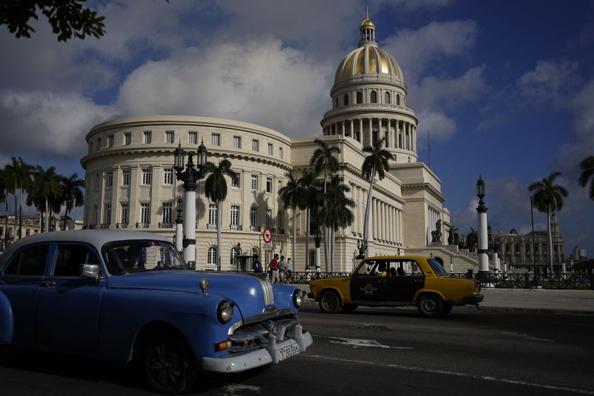 A vintage Russian-made Lada car, right, and an American-made classic car drive past the Capitol in Havana, Cuba, Friday, April 1, 2022. Global restrictions on transport and trade with Russia after its invasion of Ukraine pose a serious problem for Cubans because much of the island's fleets of trucks, buses, cars and tractors came from distant Russia and are now aging and in need of parts. (AP Photo/Ramon Espinosa)