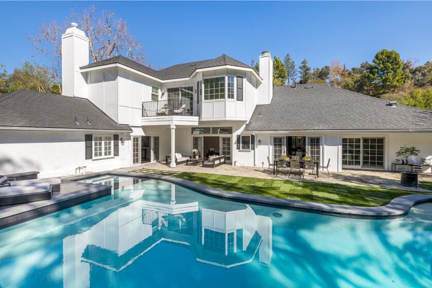 The Hamptons-style traditional makes the most of its space with a gated motor court in front and a pool in back.