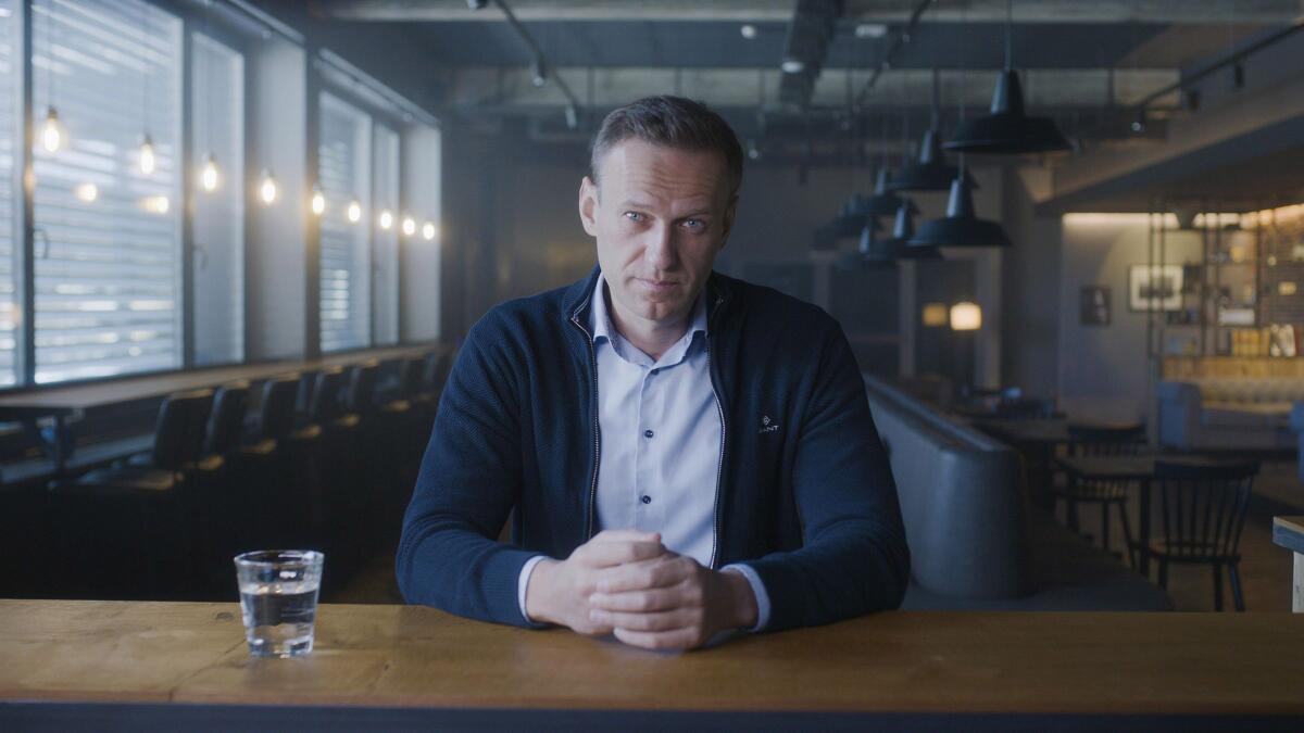A man in a dark sweater sits at a table in the documentary "Navalny."