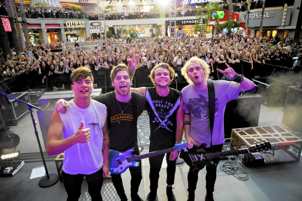 Australian pop band 5 Seconds of Summer members Calum Hood, left, Luke Hemmings, Ashton Irwin and Michael Clifford after their performance at Hollywood & Highland Center in promotion of their new album, "Sounds Good, Feels Good," Oct. 23, 2015.