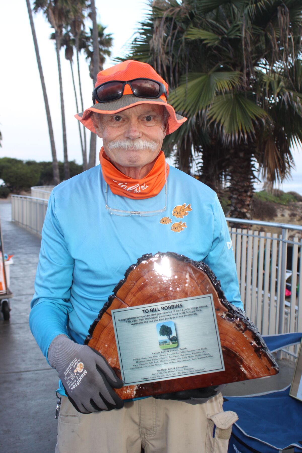 La Jolla resident Bill Robbins holds an award recognizing his community service around La Jolla Cove and Scripps Park.