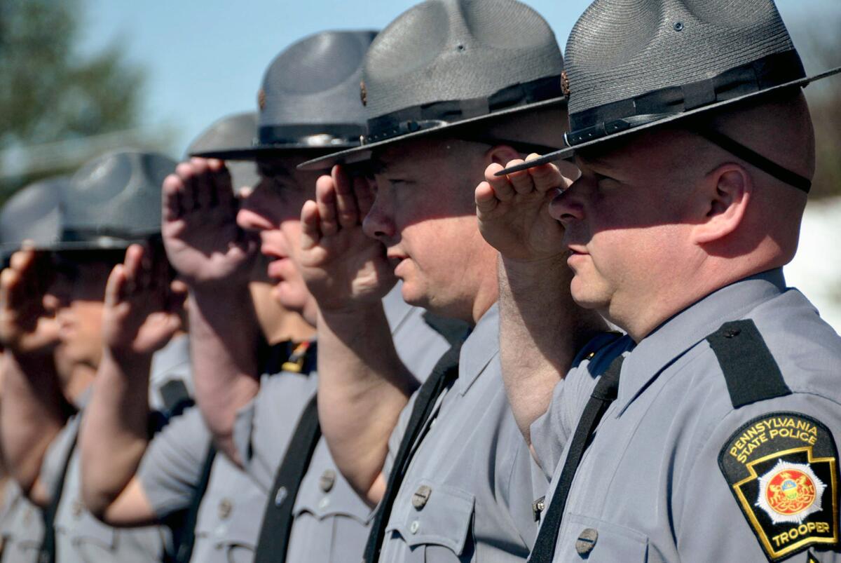 State troopers attend a memorial in West Hazleton, Pa., for fellow troopers killed in the line of duty. This week, the Department of Justice accused the agency of discriminating against women with its hiring standards.
