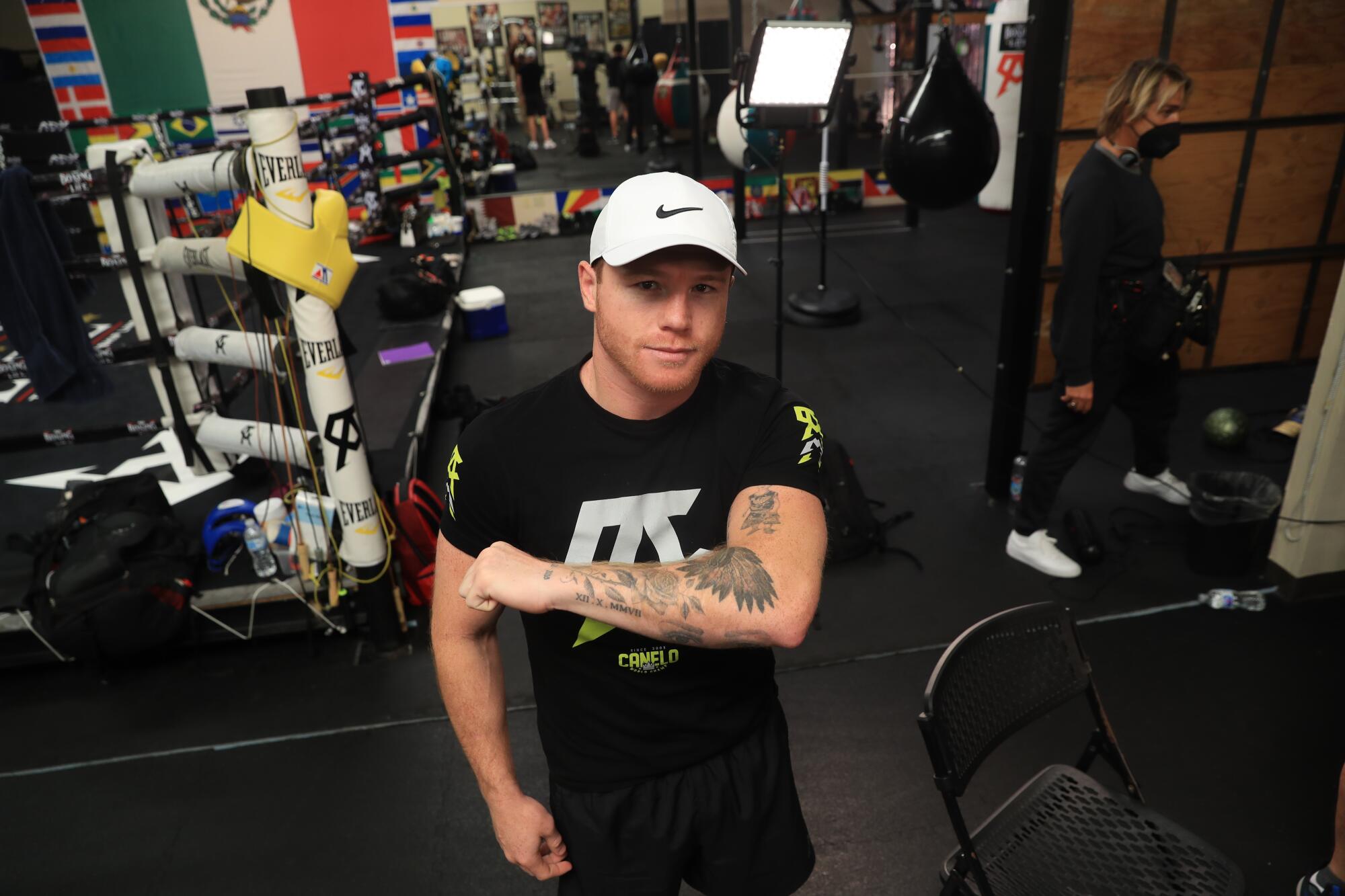 Canelo Álvarez shows off his tattoos while training at his gym in San Diego
