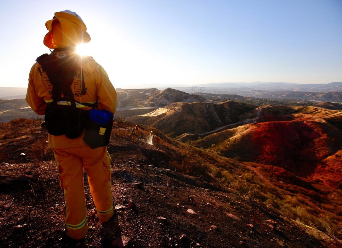 A battalion chief with the Pasadena Fire Department watches his crew. Firefighters were battling a fast-moving brush fire in the Santa Clarita area that burned 760 acres and prompted the shutdown of Highway 14 in both directions June 25, 2017. (Francine Orr / Los Angeles Times )