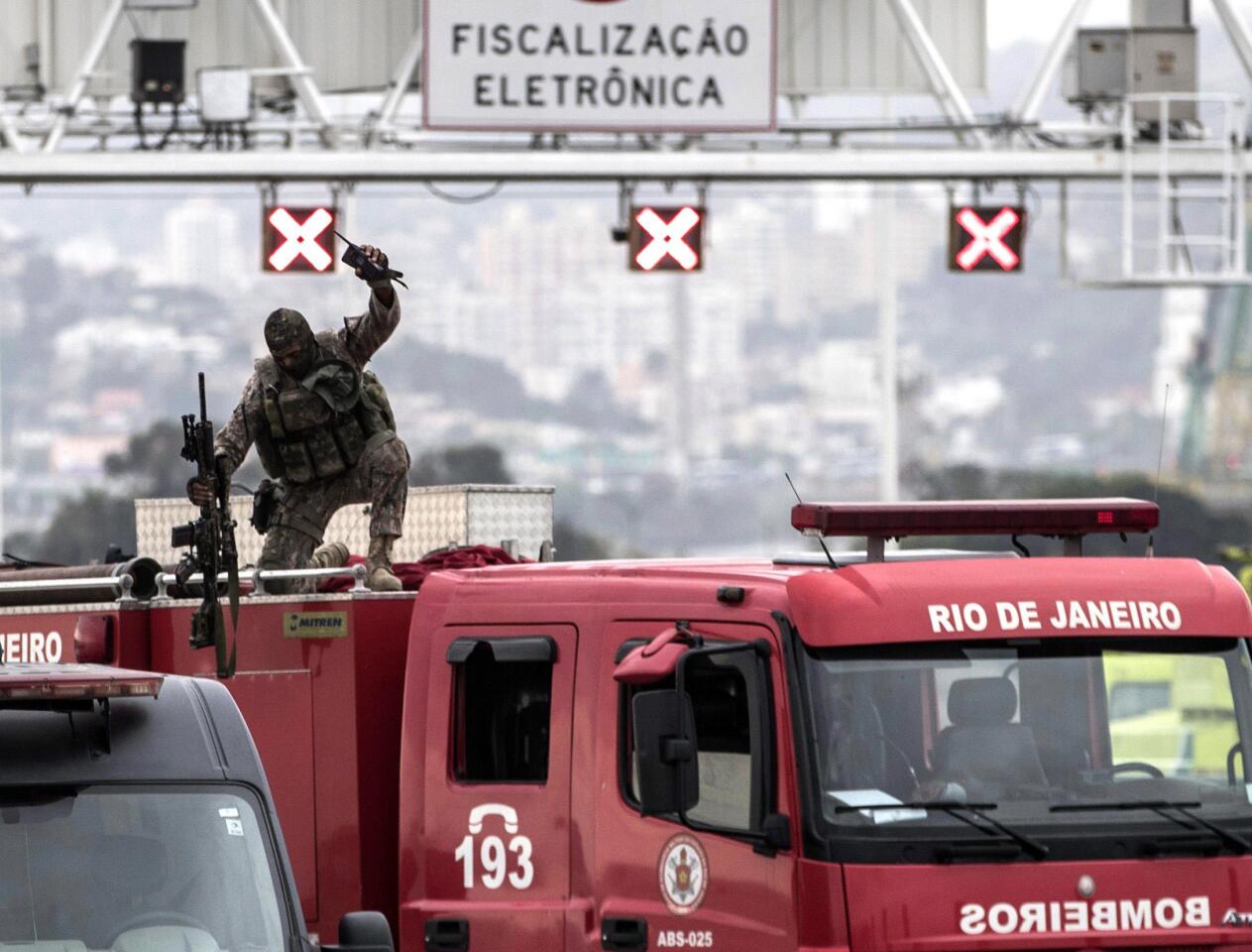 A police sniper celebrates after fatally shooting a hijacker who was threatening passengers on a bus in Rio de Janeiro on Tuesday. An armed man hijacked a bus and kept passengers and the driver as hostages while he threatened to burn the vehicle with gas.