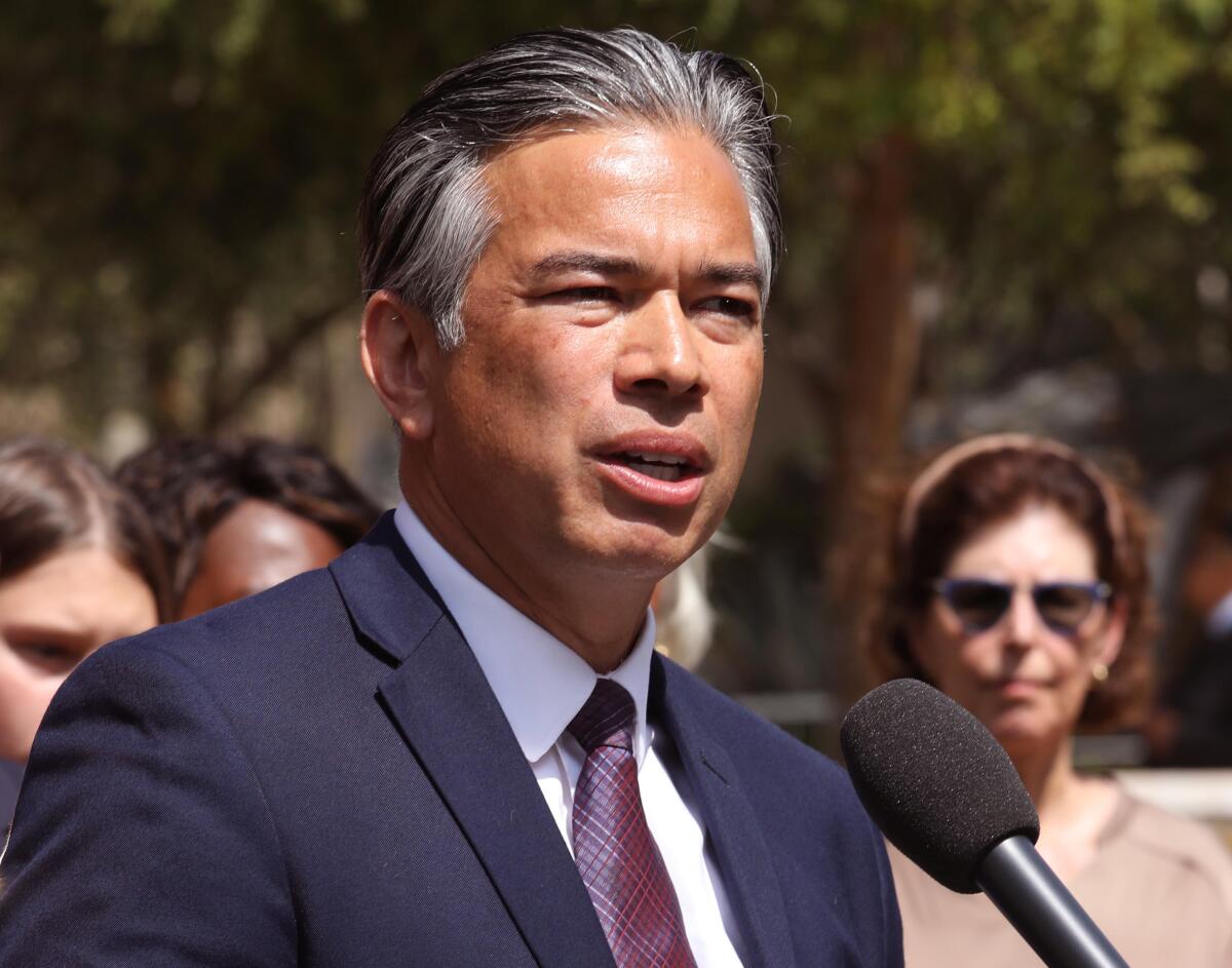 Rob Bonta speaks at a microphone during an outdoor press conference.