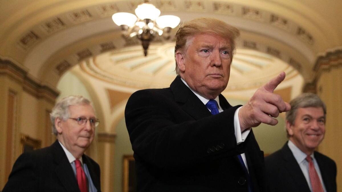 President Trump speaks to members of the media as Senate Majority Leader Sen. Mitch McConnell (R-KY) and Sen. Roy Blunt (R-MO) look on in Washington on March 26.