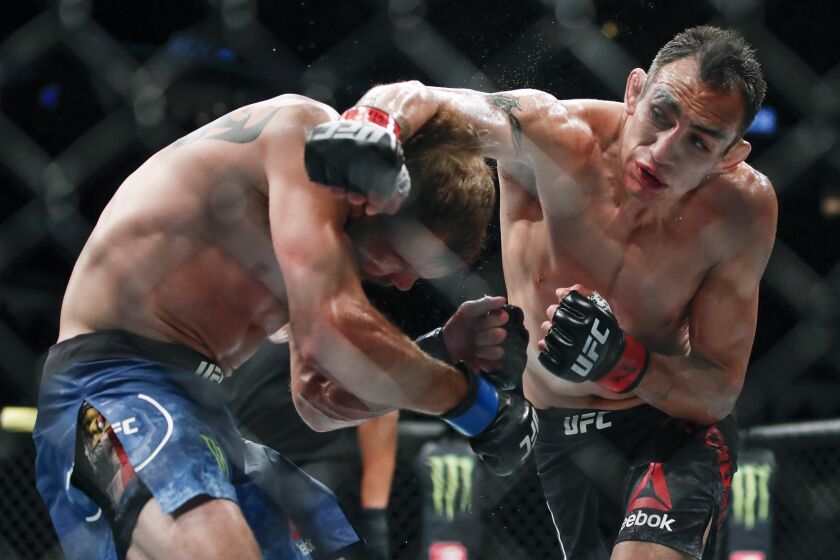 FILE - In this June 8, 2019, file photo, Tony Ferguson, right, punches Donald Cerrone, left, during their lightweight mixed martial arts bout at UFC 238 in Chicago. Ferguson and Justin Gaethje will headline the mixed martial arts card at UFC 249 behind closed doors at Veterans Memorial Arena in Jacksonville, Fla., Saturday, May 9, 2020. UFC 249 will serve as the first major sporting event to take place since the coronavirus pandemic shut down much of the country nearly two months ago. (AP Photo/Kamil Krzaczynski, File)