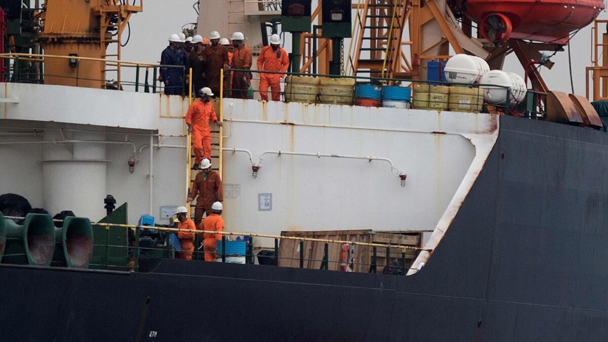 Crew members walk down a ladder on Grace 1, an Iranian tanker seized by Gibraltar.