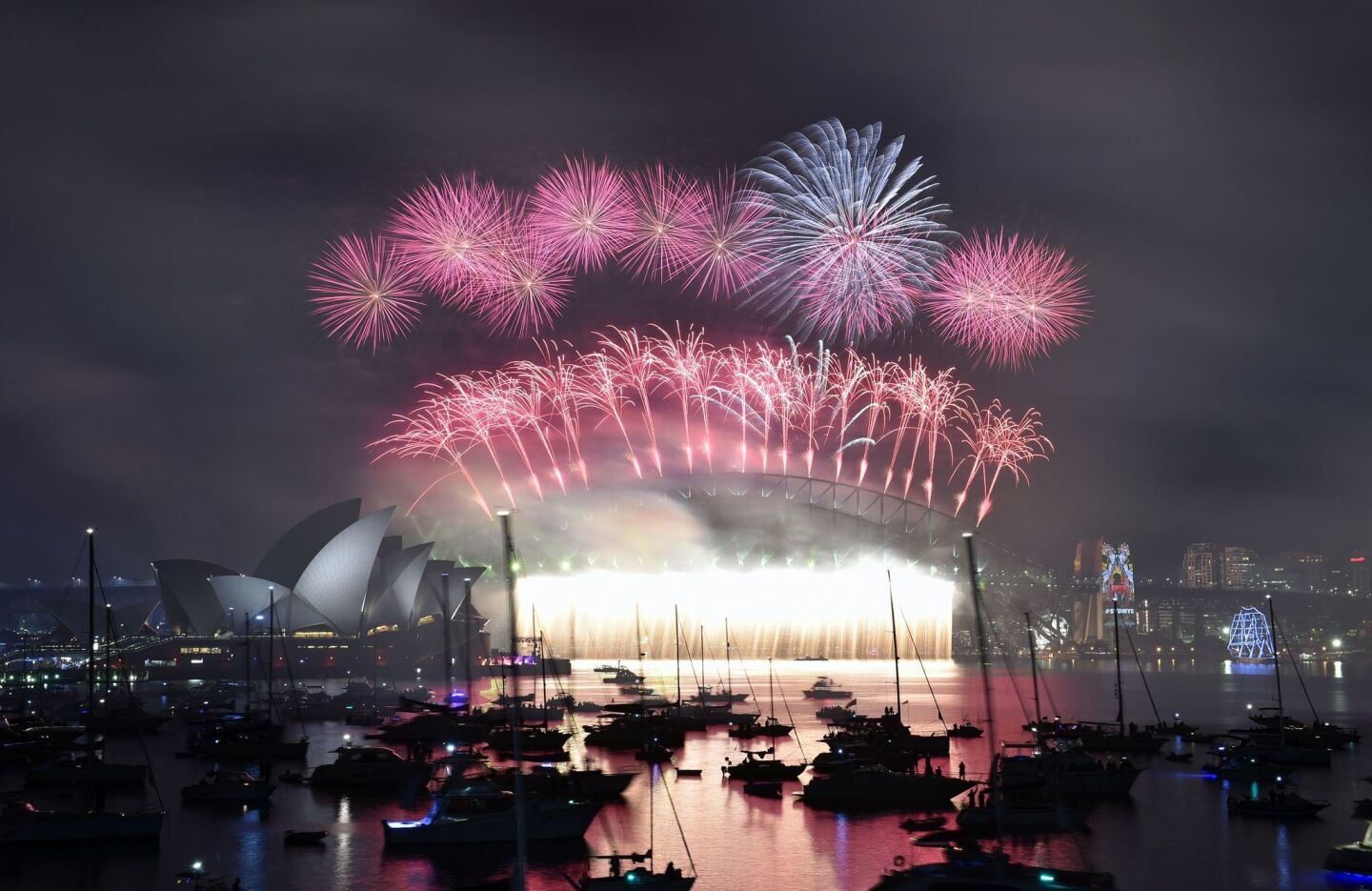 New Year's fireworks light up the sky over Sydney, Australia's Opera House, left, and Harbour Bridge.
