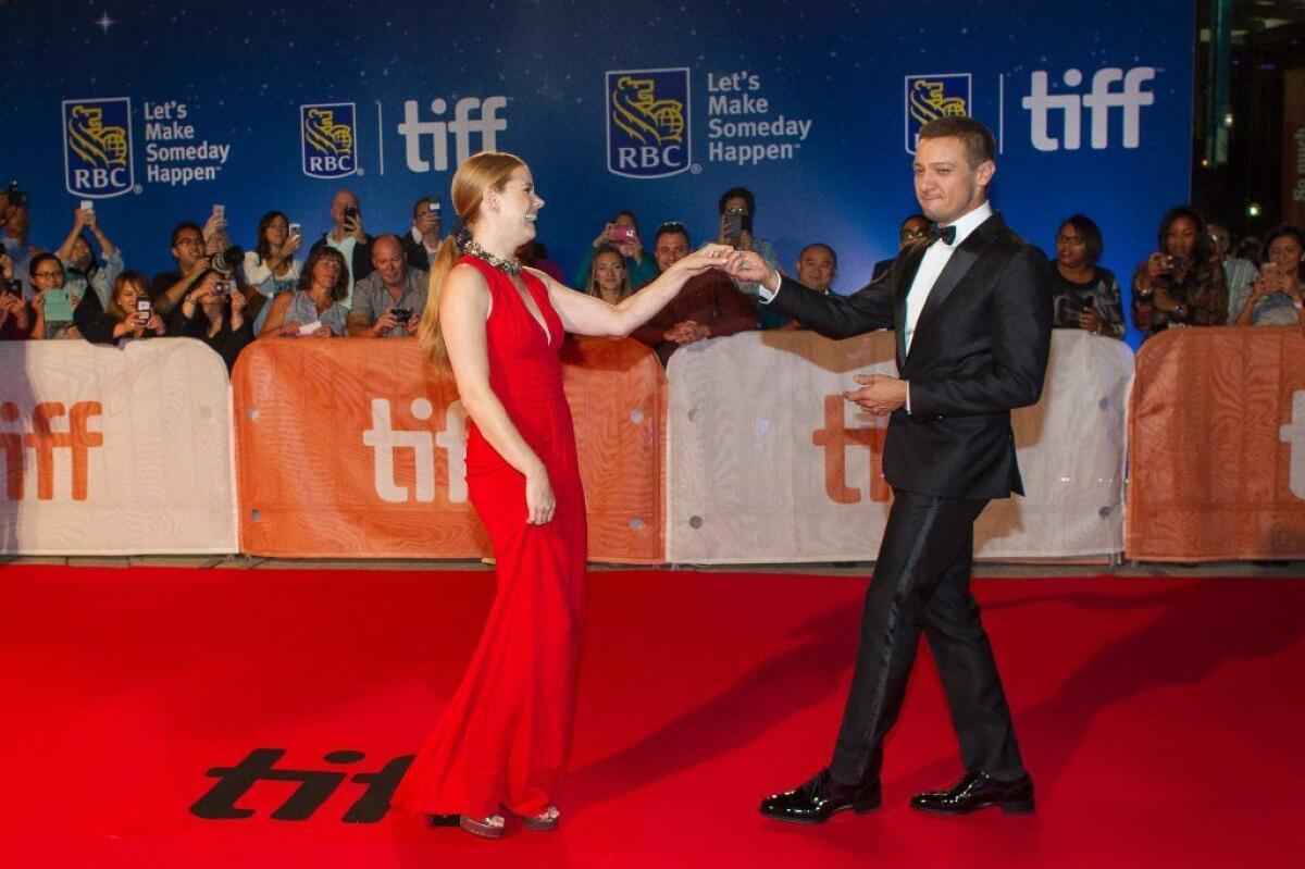 Amy Adams and Jeremy Renner pose for photographers during the premiere of "Arrival" at the Toronto International Film Festival, September 12, 2016.