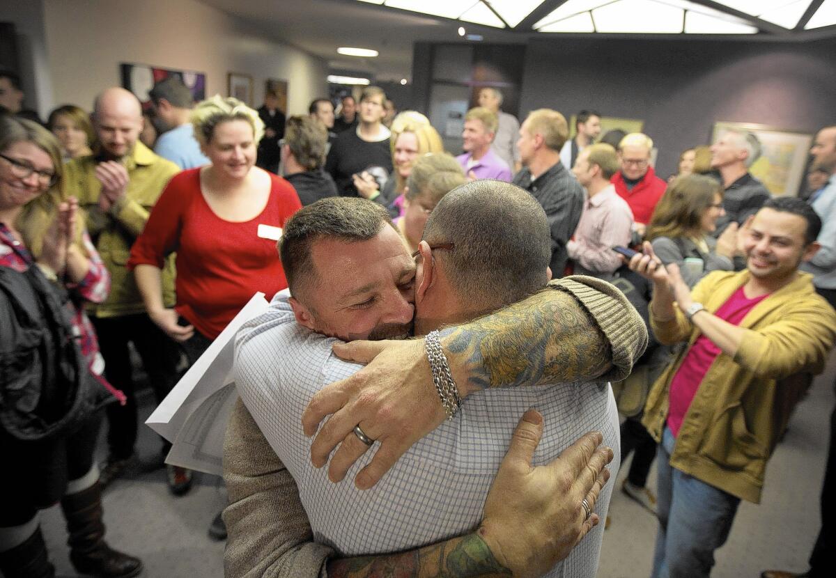 Chris Serrano, left, and Clifton Webb embrace after being married in Salt Lake City in December.