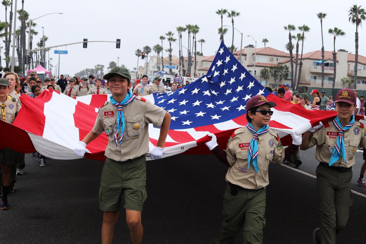 Scout troops hold the historic Freedoms Flag for the start of Huntington Beach's 120th Annual Fourth of July Parade.