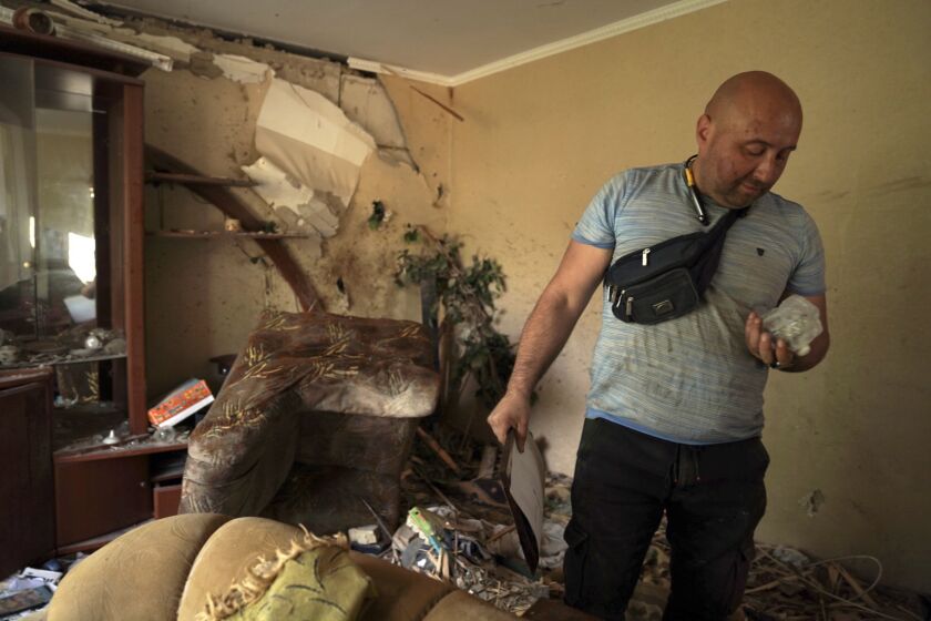 Denis Alyoshyn seeks to salvage whatever he can from his family's bombed out apartment in Borodyanka