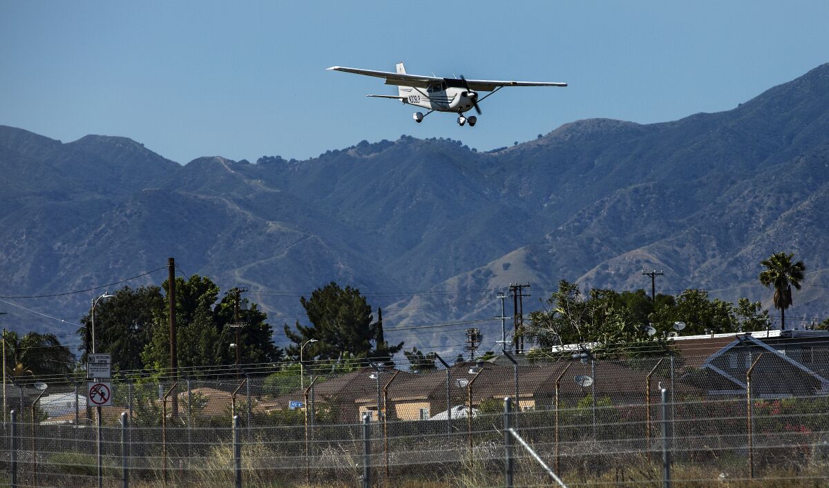 A plane flies over low homes near Whiteman Airport in Pacoima.
