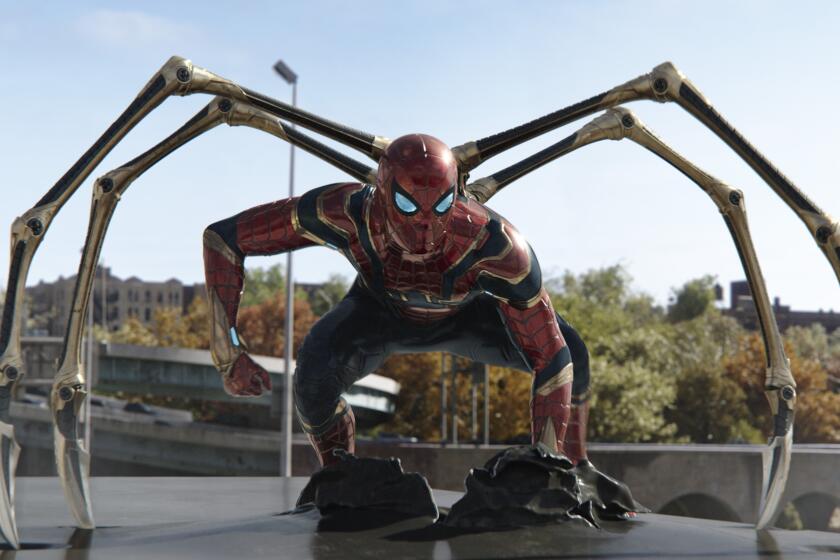 A man crouching in a metallic Spider-Man suit with arms protruding from its back