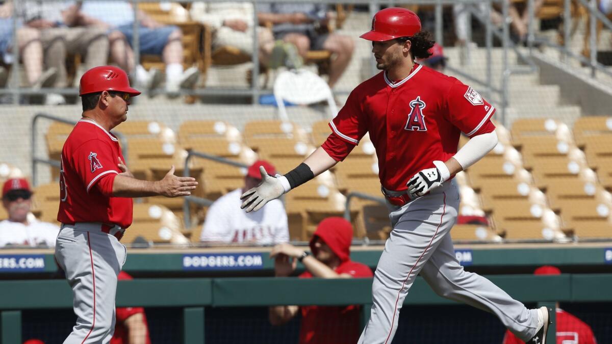 Angels outfielder Jarrett Parker, right, is congratulated by third base coach Mike Gallego after hitting a home run in the second inning of Monday's game against the Chicago White Sox.