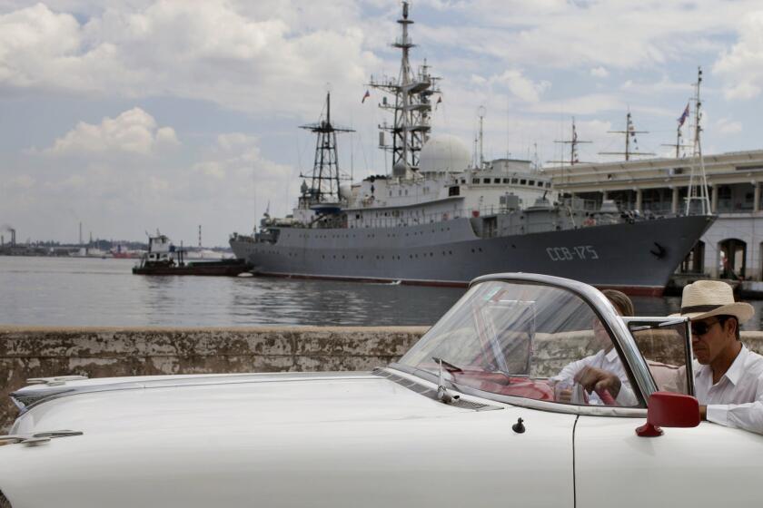 An American classic car passes in front of the Russian warship, The Viktor Leonov CCB-175, docked in Havana's harbor in Havana, Cuba. Despite the absence of official diplomatic relations, Cuba remains a major component of U.S. foreign policy.