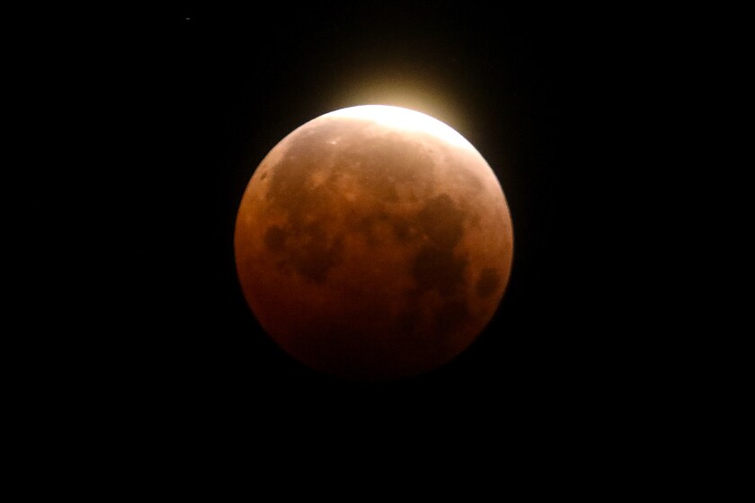 Light shines from a total lunar eclipse over Santa Monica Beach on May 26, 2021.