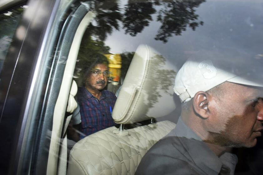 Arvind Kejriwal, líder del Partido Aam Admi, o Partido del Hombre Común, izquierda, baja de un auto después de que un tribunal extendió su arresto cuatro días más en Nueva Delhi, India, el jueves 28 de marzo de 2024. (AP Foto/Dinesh Joshi)