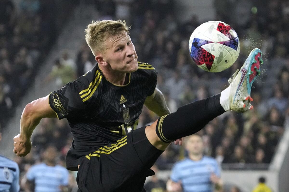 LAFC midfielder Mateusz Bogusz kicks a ball against Sporting Kansas City.