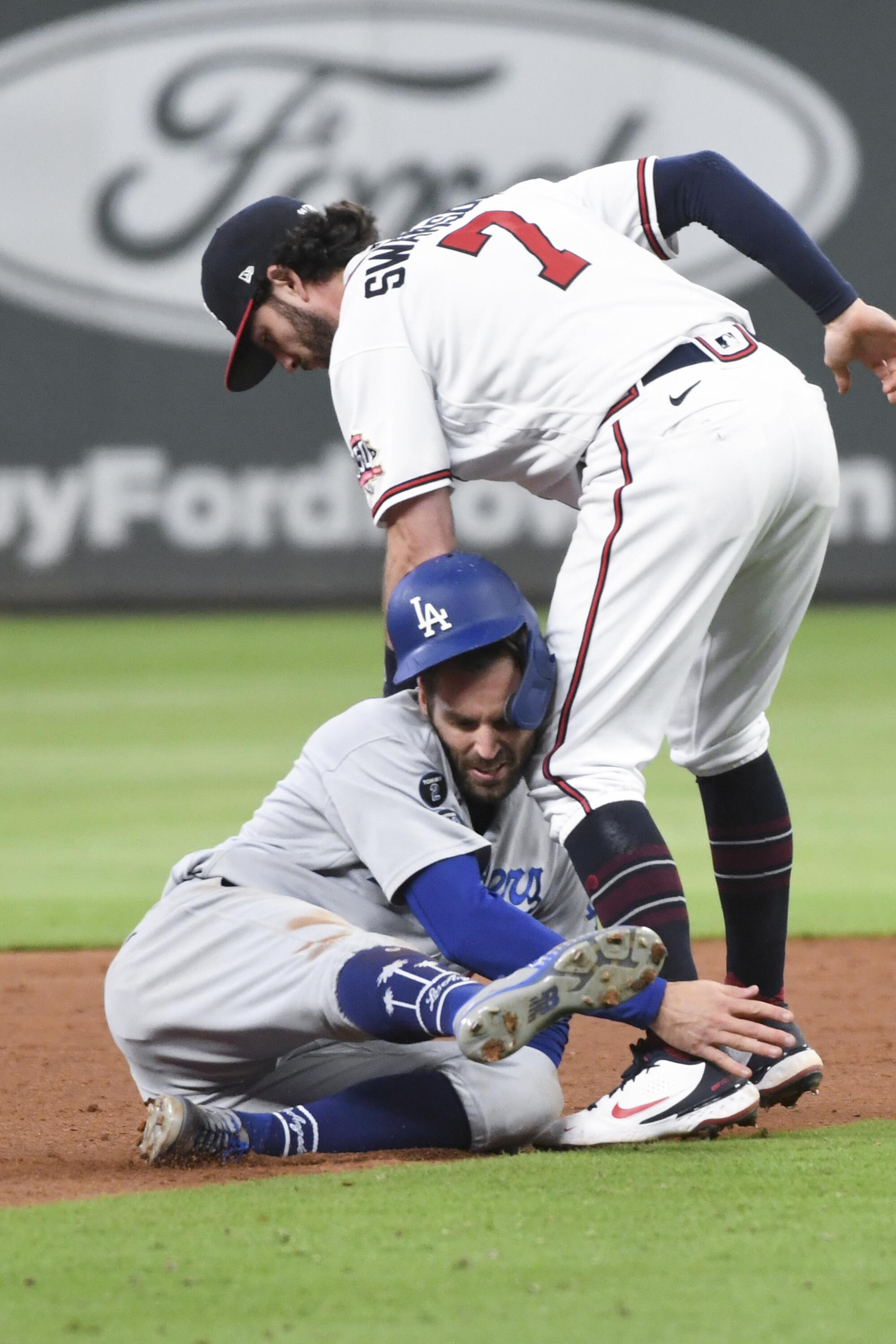 Atlanta Braves shortstop Dansby Swanson, right, tags out Los Angeles Dodgers' Chris Taylor