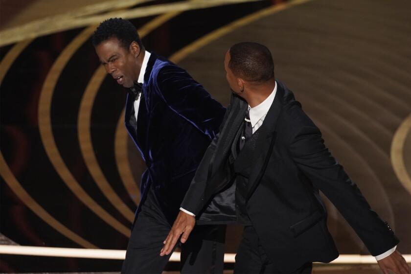 Will Smith, derecha, golpea al presentador Chris Rock en el escenario al presentar el premio a mejor largometraje documental en los Oscar el domingo 27 de marzo de 2022 en el Teatro Dolby en Los Angeles. (Foto AP/Chris Pizzello)