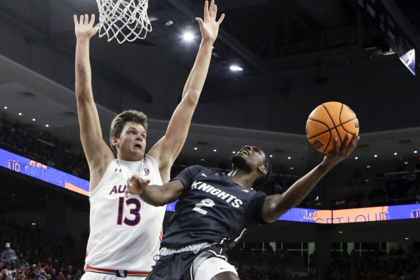 Central Florida guard Darius Perry (2) shoots as Auburn forward Walker Kessler (13) defends during the first half of an NCAA college basketball game Wednesday, Dec. 1, 2021, in Auburn, Ala. (AP Photo/Butch Dill)