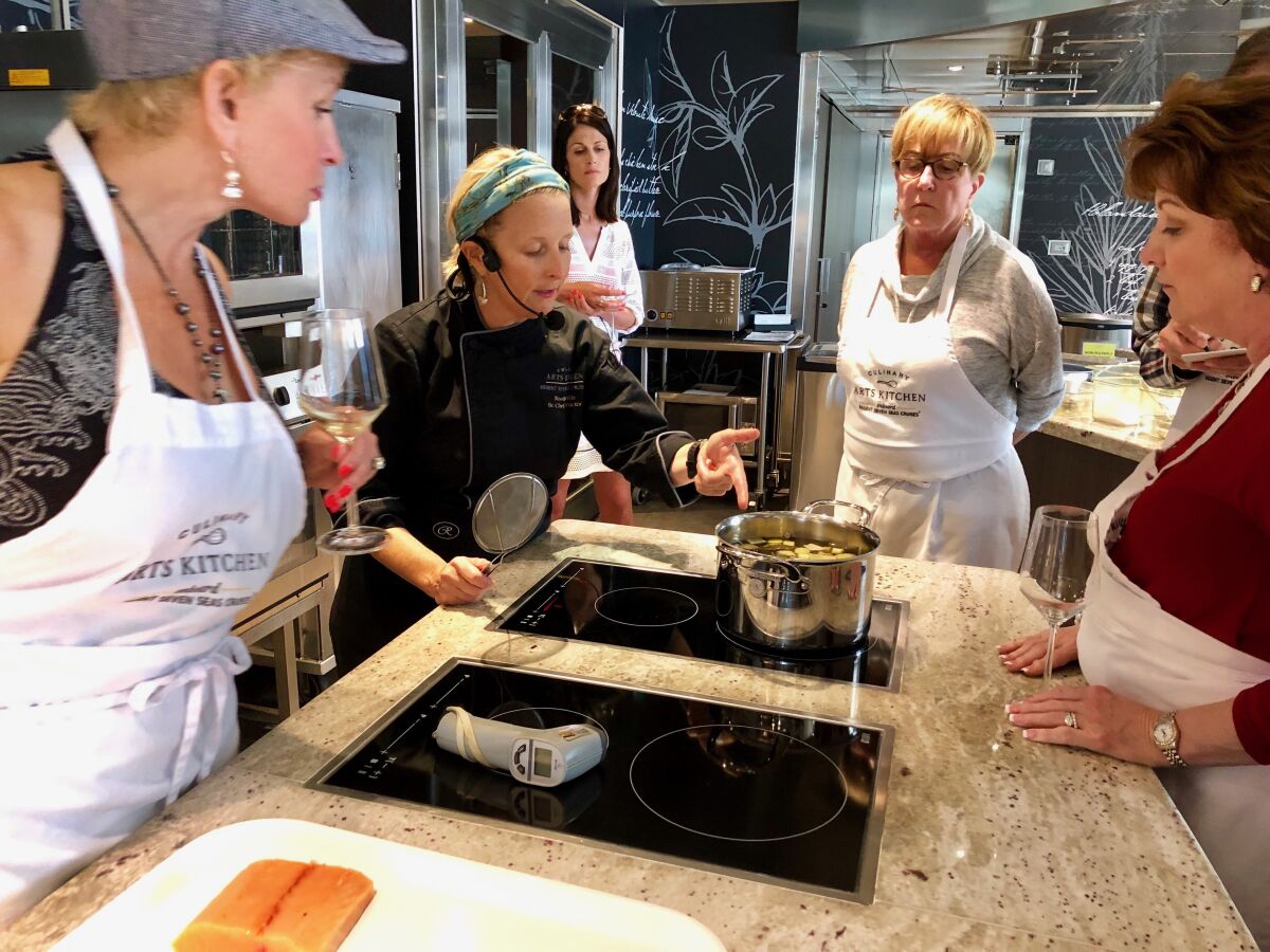 Noëlle Barille coaches students in a French cooking class aboard Regent Seven Seas Explorer.