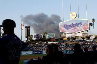 Smoke can be seen from Dodger Stadium during an afternoon game on Saturday, Sept. 21, 2024. The fire destroyed a 100-foot-by-200-foot, single-story former courthouse-turned-commercial building at 1158 N. San Fernando Rd., according to a Los Angeles Fire Department statement.