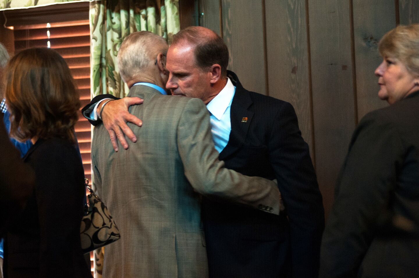 University of Missouri System President Tim Wolfe, at right, hugs university curator Marcy Graham after announcing his resignation during a Board of Curators meeting Monday at the University of Missouri in Columbia, Mo. FOR THE RECORD: An earlier version of this caption misidentified Wolfe; he is at right, not center.