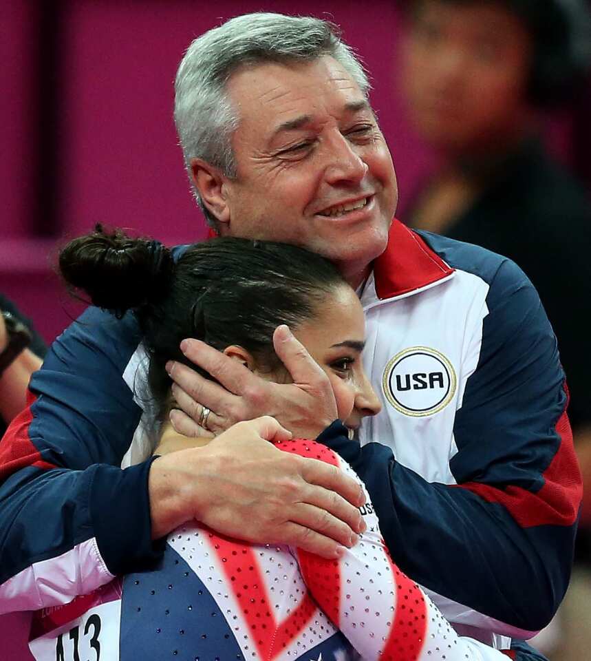 Coach Mihai Brestyan hugs American gymnast Aly Raisman after she completed her routine in the women's floor exercise. She won the gold medal, becoming the first American woman to win gold in that event.