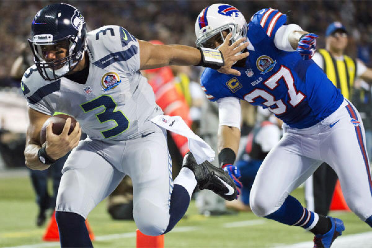 Seattle quarterback Russell Wilson runs the ball into the end zone past Buffalo's George Wilson during a 2012 game in Toronto.