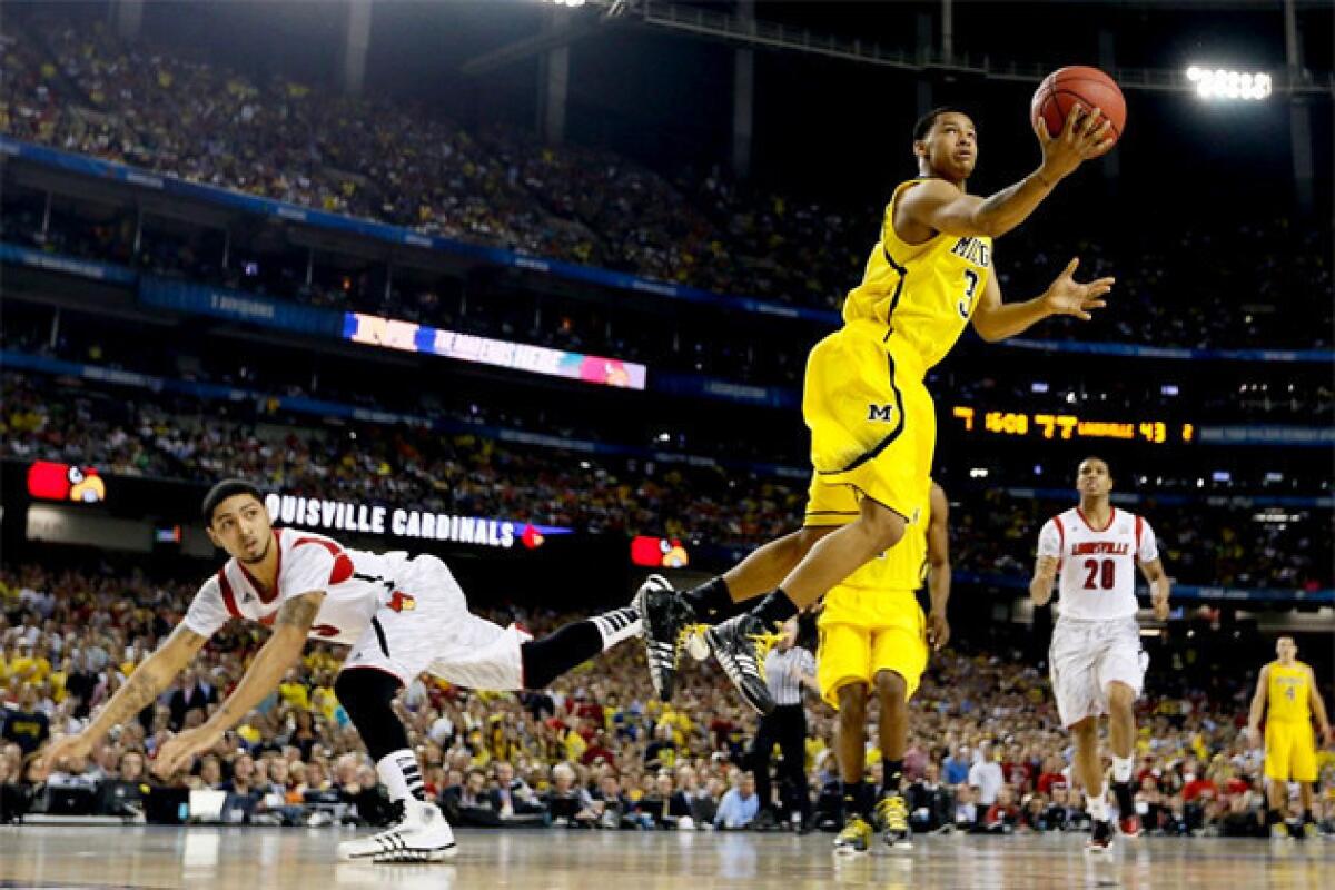 Michigan guard Trey Burke, right, is leaving the Wolverines to enter the NBA draft.