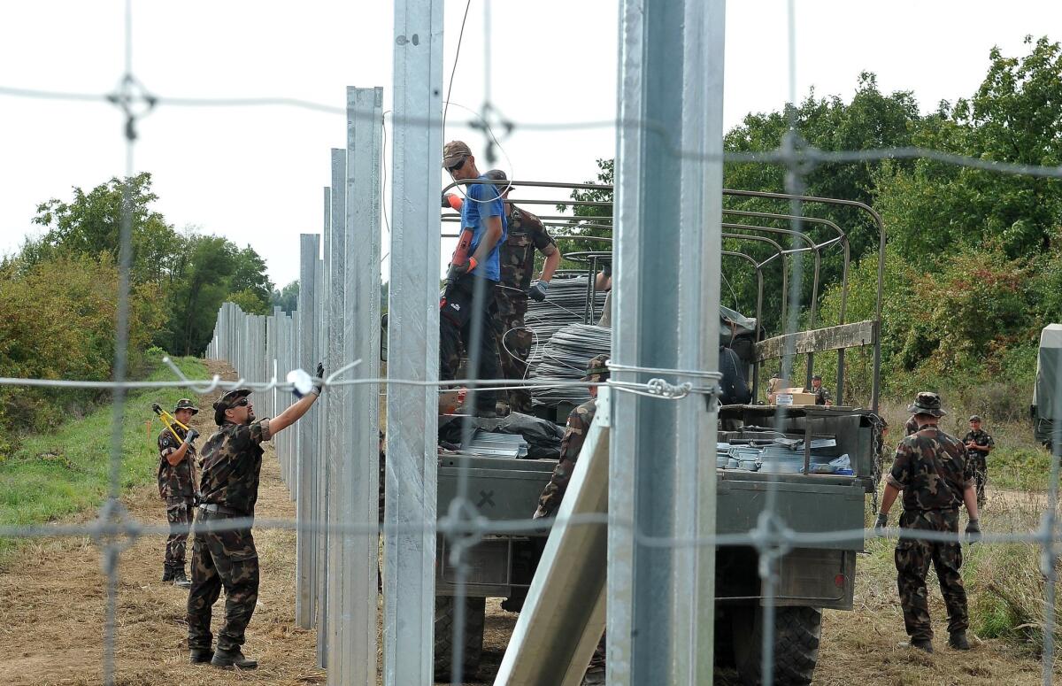 Hungarian soldiers raise fences at the border with Croatia on Sept. 22.