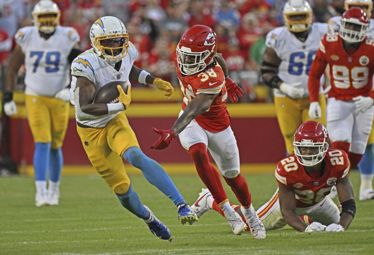 Chargers receiver Joshua Palmer, second from left, tries to elude Chiefs cornerback L'Jarius Sneed after making a reception. 