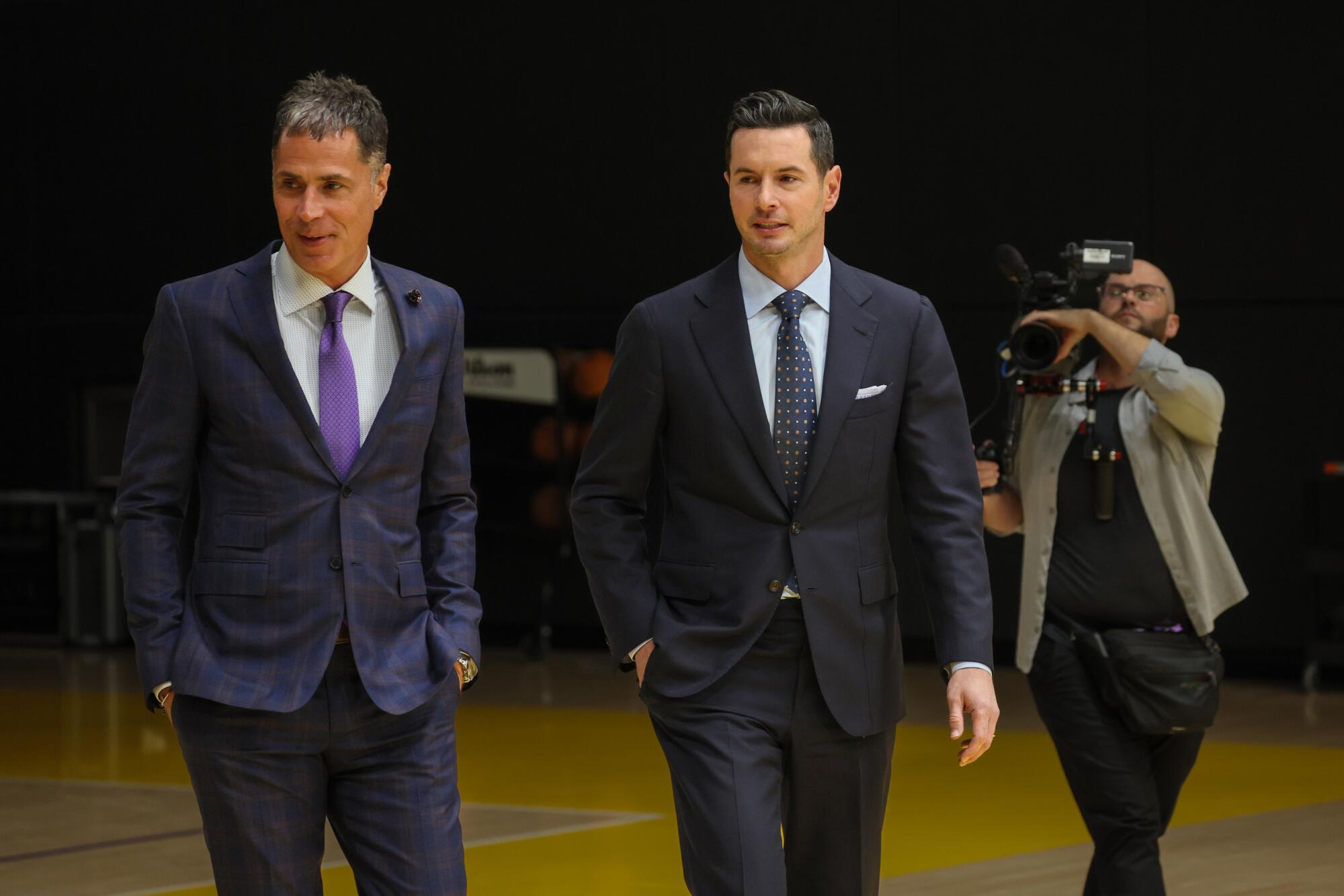 Lakers top basketball executive Rob Pelinka, left, arrives with JJ Redick at the team's training center for a news conference