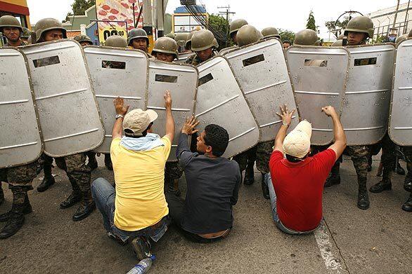 Supporters of ousted Zelaya converge at the airport. The army fired tear gas at the protesters; some witnesses said live ammunition was fired too. The Red Cross said one protester, about 19, was shot dead.