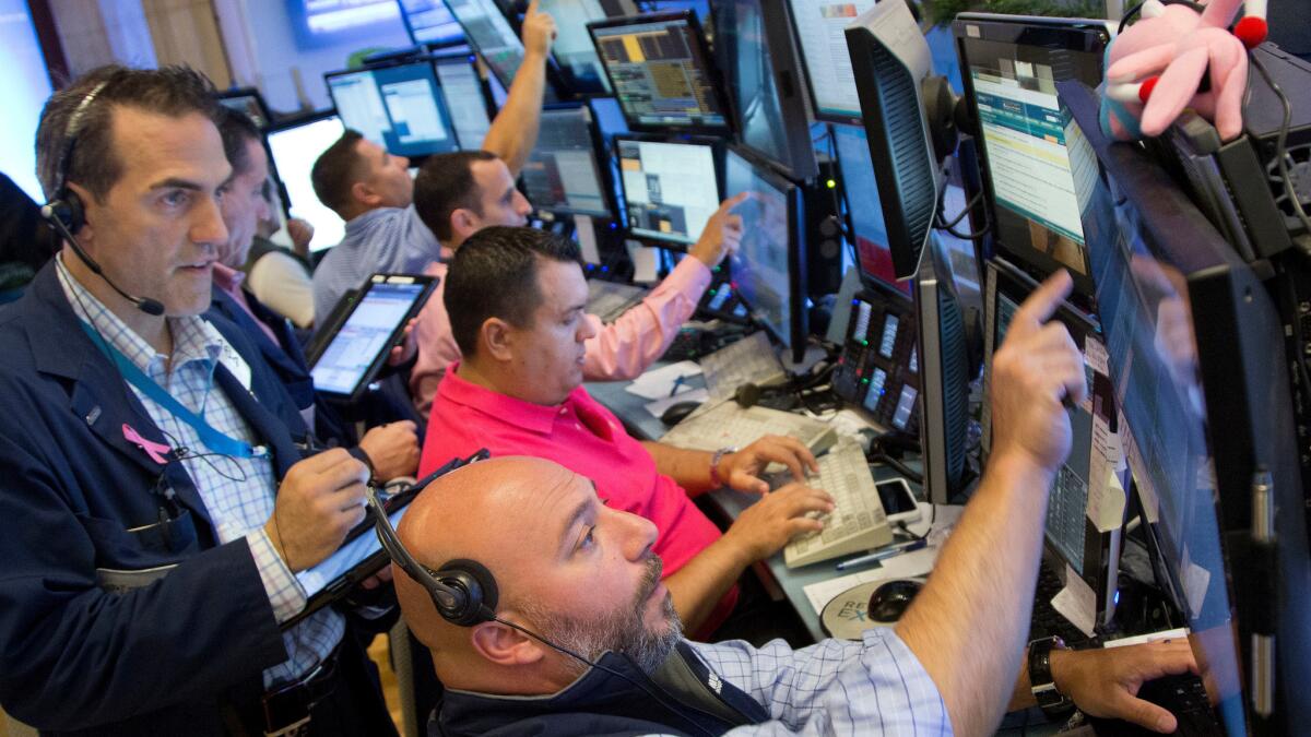 Greg Rowe, left, and Vincent Napolitano, bottom, with Livermore Trading Group monitor stock prices at the New York Stock Exchange on Friday.