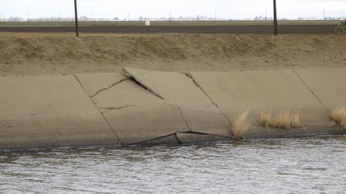 A buckle in the lining of the Delta Mendota Canal, seen in this photo taken in December, is caused by sinking land. Years of drought and heavy reliance on groundwater pumping have made the land sink faster than ever up and down California's Central Valley.