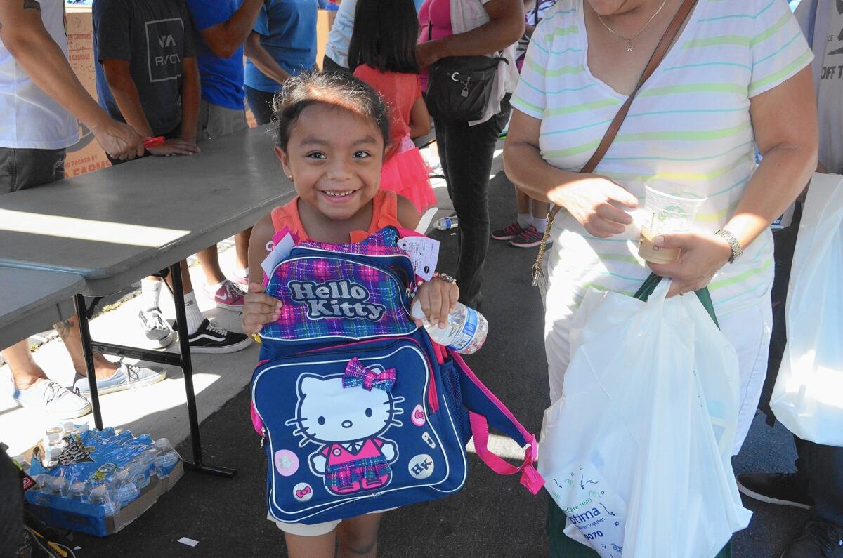 First-grader Sandra Morales, 6 is proud of her new Hello Kitty backpack that she received during Share Our Selves' 20th annual Back to School event Saturday at The Crossing Church in Costa Mesa.