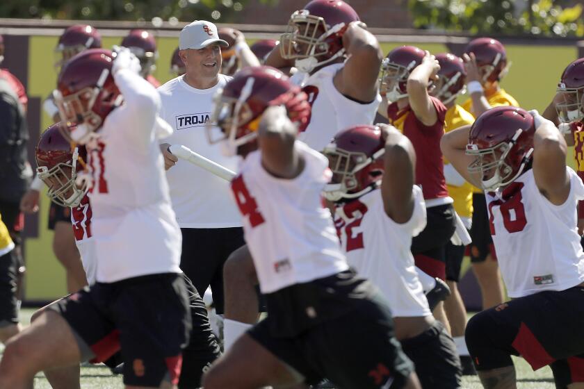 LOS ANGELES, CALIF. - AUG. 2, 2019. Head football coach Clay Helton runs players through warm-ups during the opening of training camp at USC on Friday, Aug. 2, 2019. Helton heads into his fifth season as the Trojans' head coach with a record of 32-17. (Luis Sinco/Los Angeles Times)