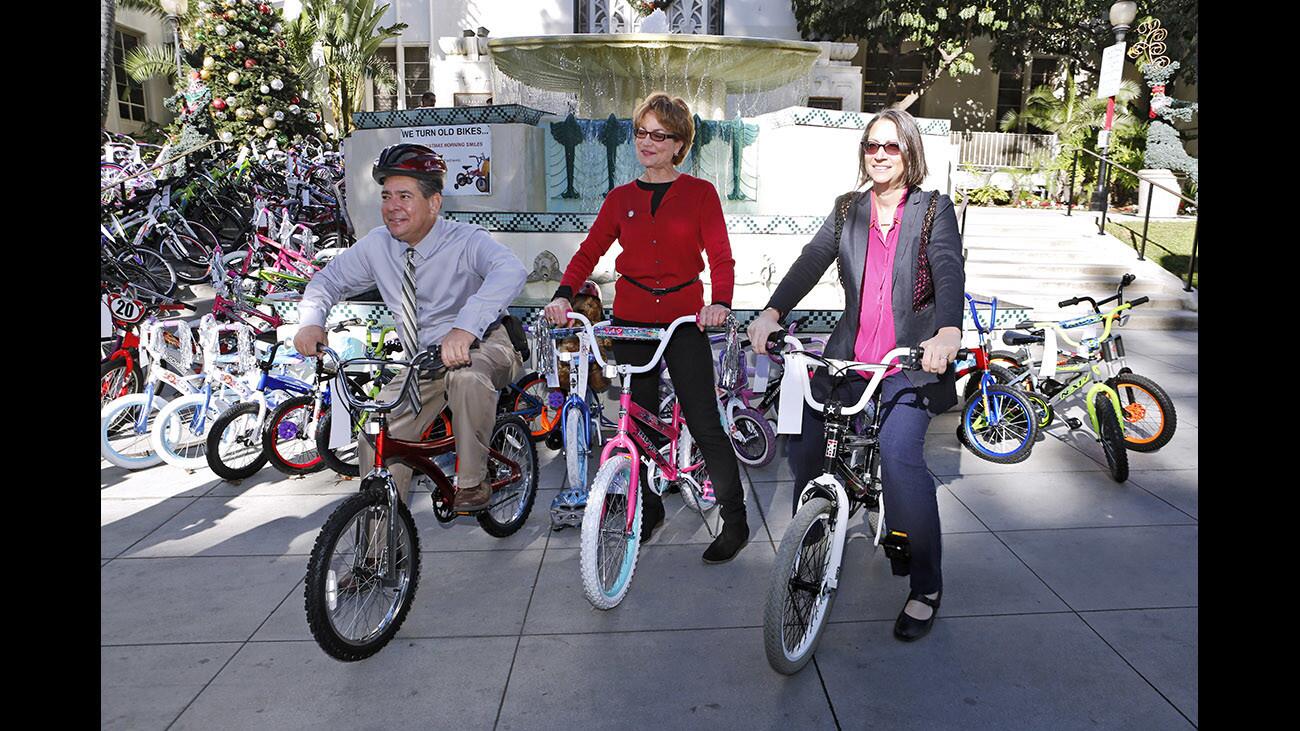 Burbank city councilmembers Bob Frutos, left, and Sharon Springer, center, joined California assemblymember Laura Friedman in posing for a photo on children’s bicycles during annual Burbank Bike Angels press conference, in front of city hall in Burbank on Wednesday, Dec. 13, 2017. Bike Angels collects used bikes throughout the year and restores them to give away to needy children during Christmas. The group, on its ninth year, collects about 100 bikes each year.