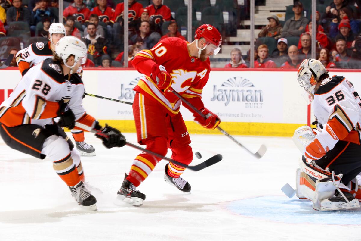 Calgary Flames forward Jonathan Huberdeau tries to control the puck in front of Ducks goaltender John Gibson.