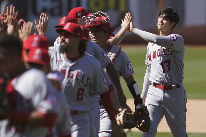 Los Angeles Angels designated hitter Shohei Ohtani, right, celebrates with teammates after the Angels defeated the Oakland Athletics in a baseball game in Oakland, Calif., Sunday, May 30, 2021. (AP Photo/Jeff Chiu)