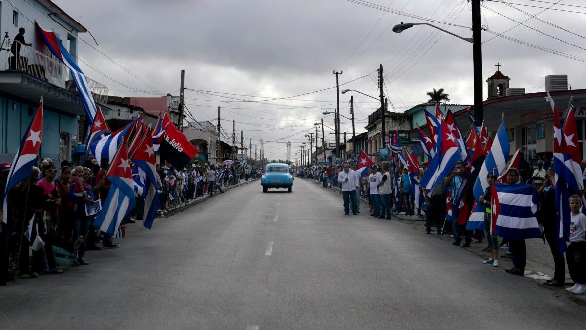 People wait Thursday to see the convoy carrying the ashes of Cuban leader Fidel Castro at Jatibonico, Cuba.
