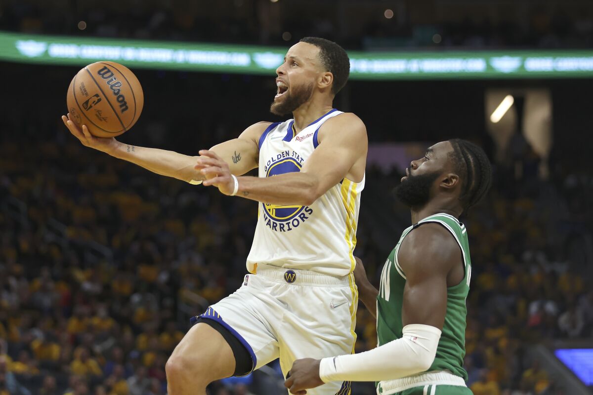 Golden State Warriors guard Stephen Curry shoots against Boston Celtics guard Jaylen Brown.