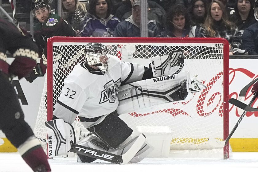 Los Angeles Kings goaltender Jonathan Quick, right, makes a glove save as Arizona Coyotes center Nick Schmaltz.