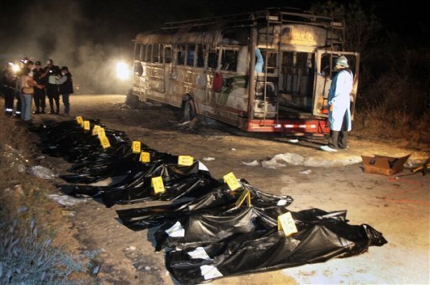 In this photo released by Guatemala Fire Department, the bodies of fifteen people lie on the ground after a bus fire in Zacapa, Guatemala, Sunday, Nov. 9, 2008. Police are investigating possible gang ties to the bus fire on a rural road in Zacapa, an eastern region notorious for drug violence.(AP Photo/Jose Rodriguez/Guatemala Fire Department)
