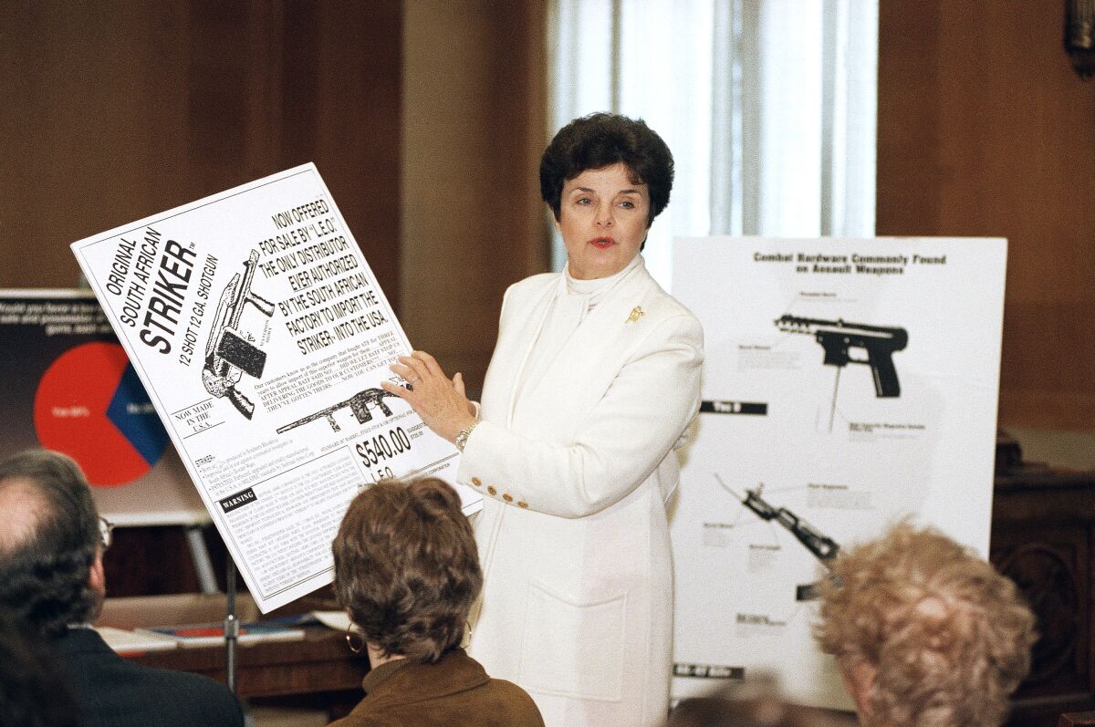 A woman dressed in white holds up an advertisement for a  shotgun at a news conference  